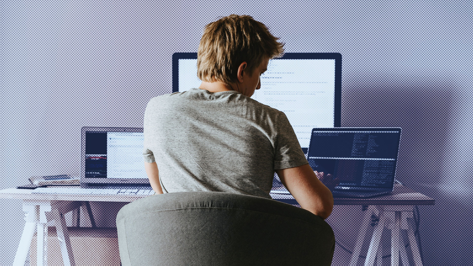 Man working on several computers