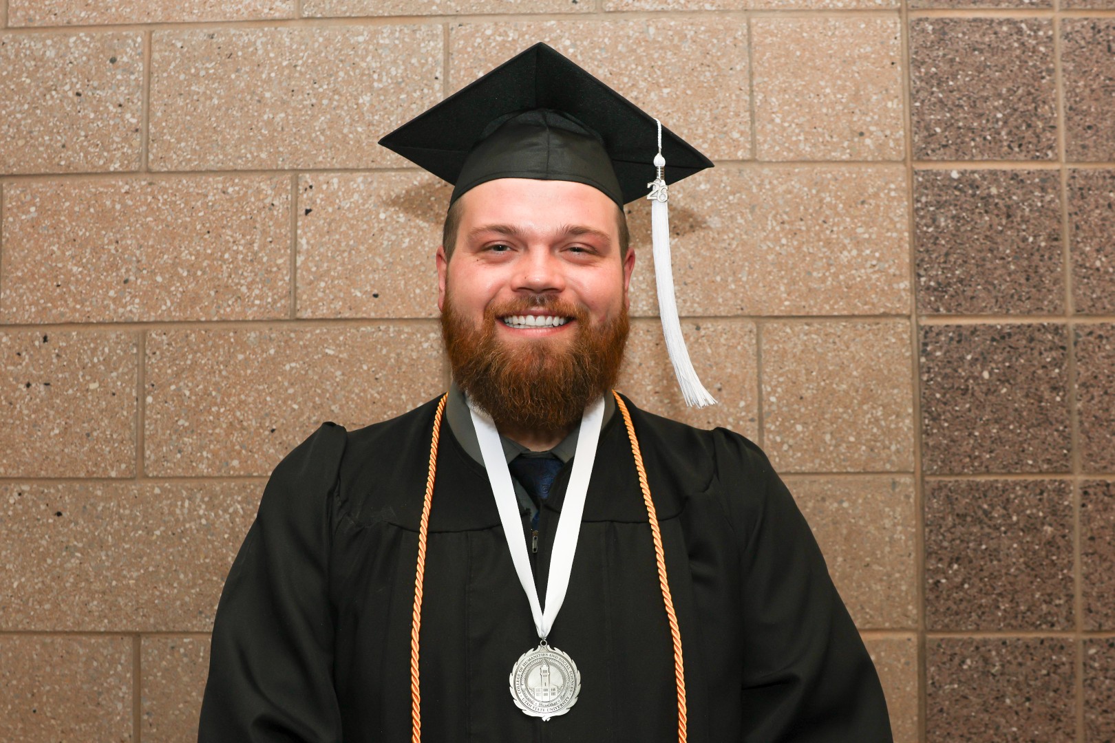 jacob berry poses in graduation gown