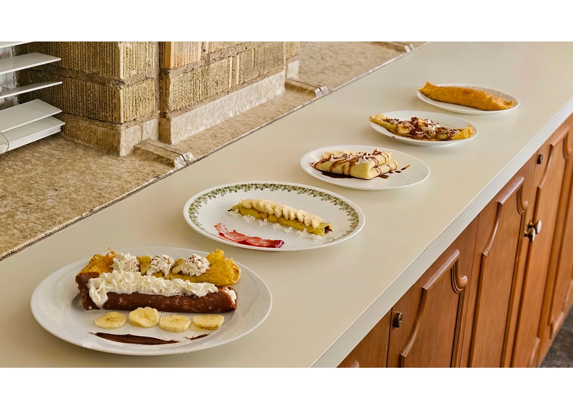 multiple crepes displayed on plates in a row