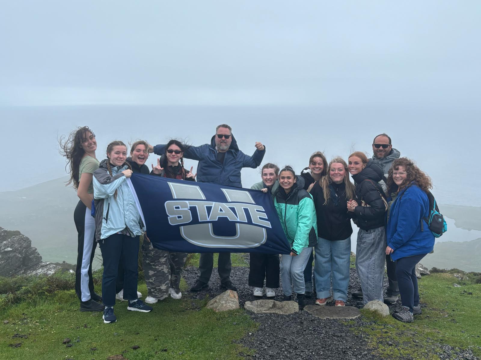 photo of students holding usu flag in ireland