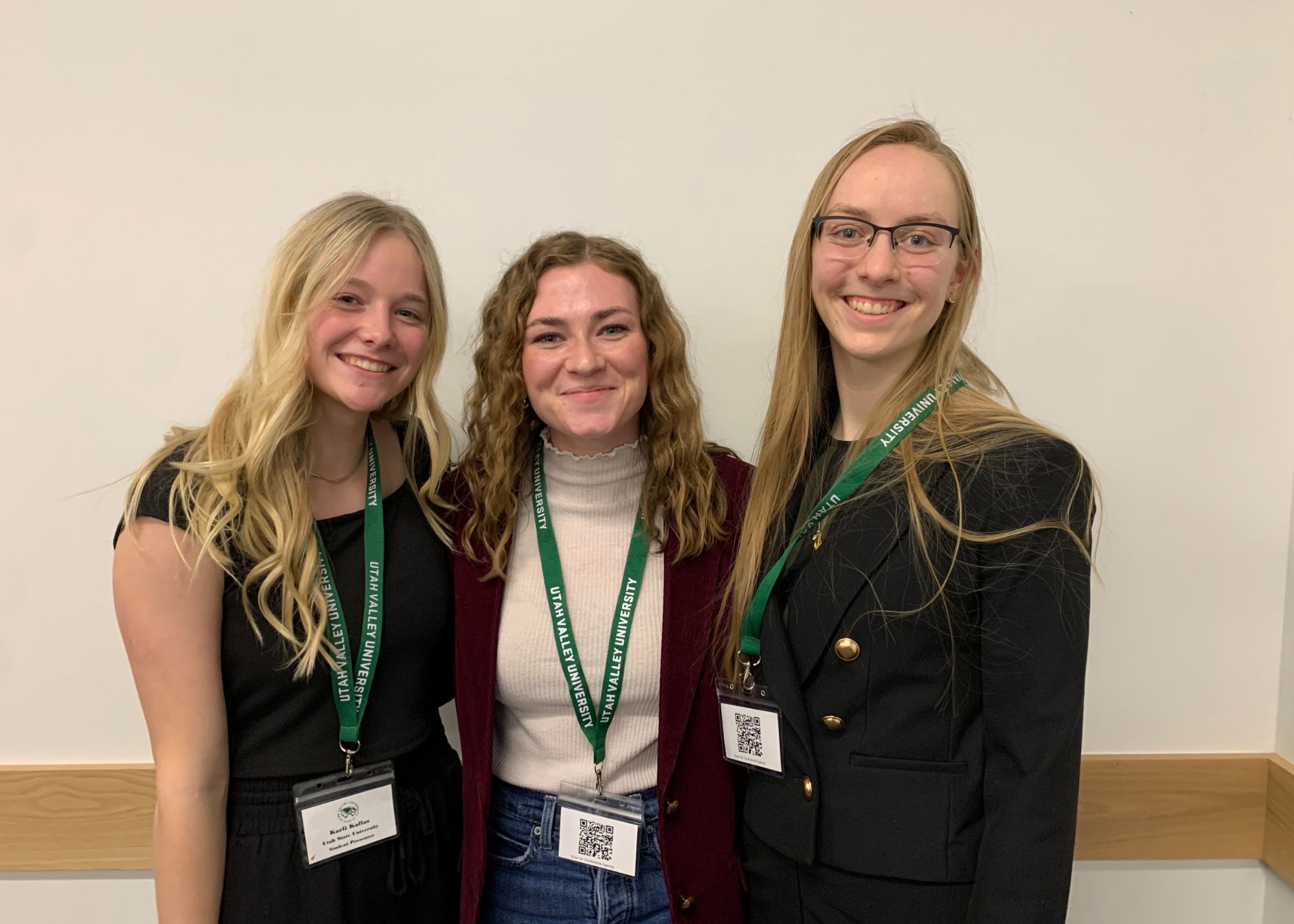 Undergraduates Karli Kallas and Maren Archibald posing for the camera wearing their research conference landyards