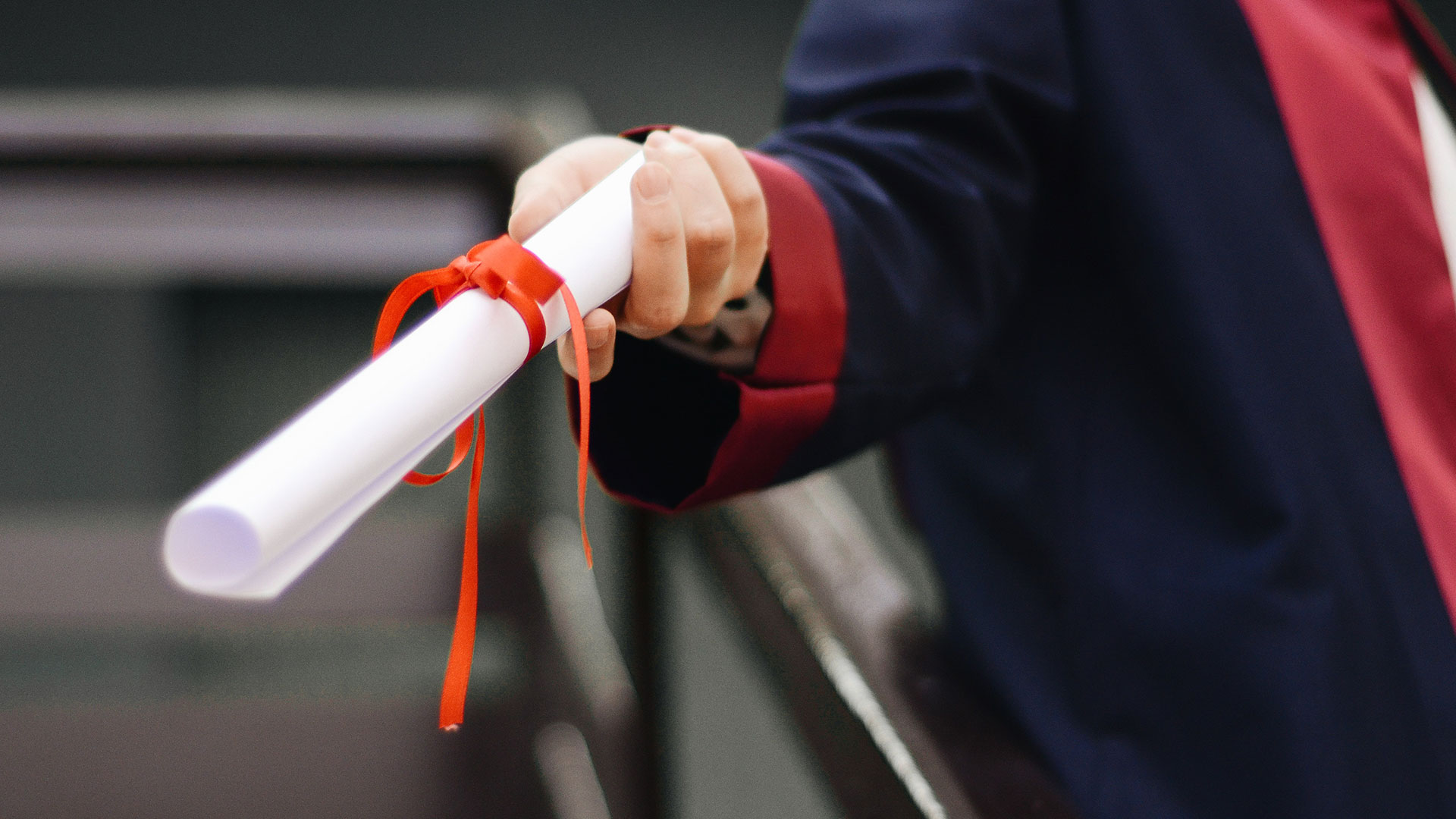graduate holding out a scroll