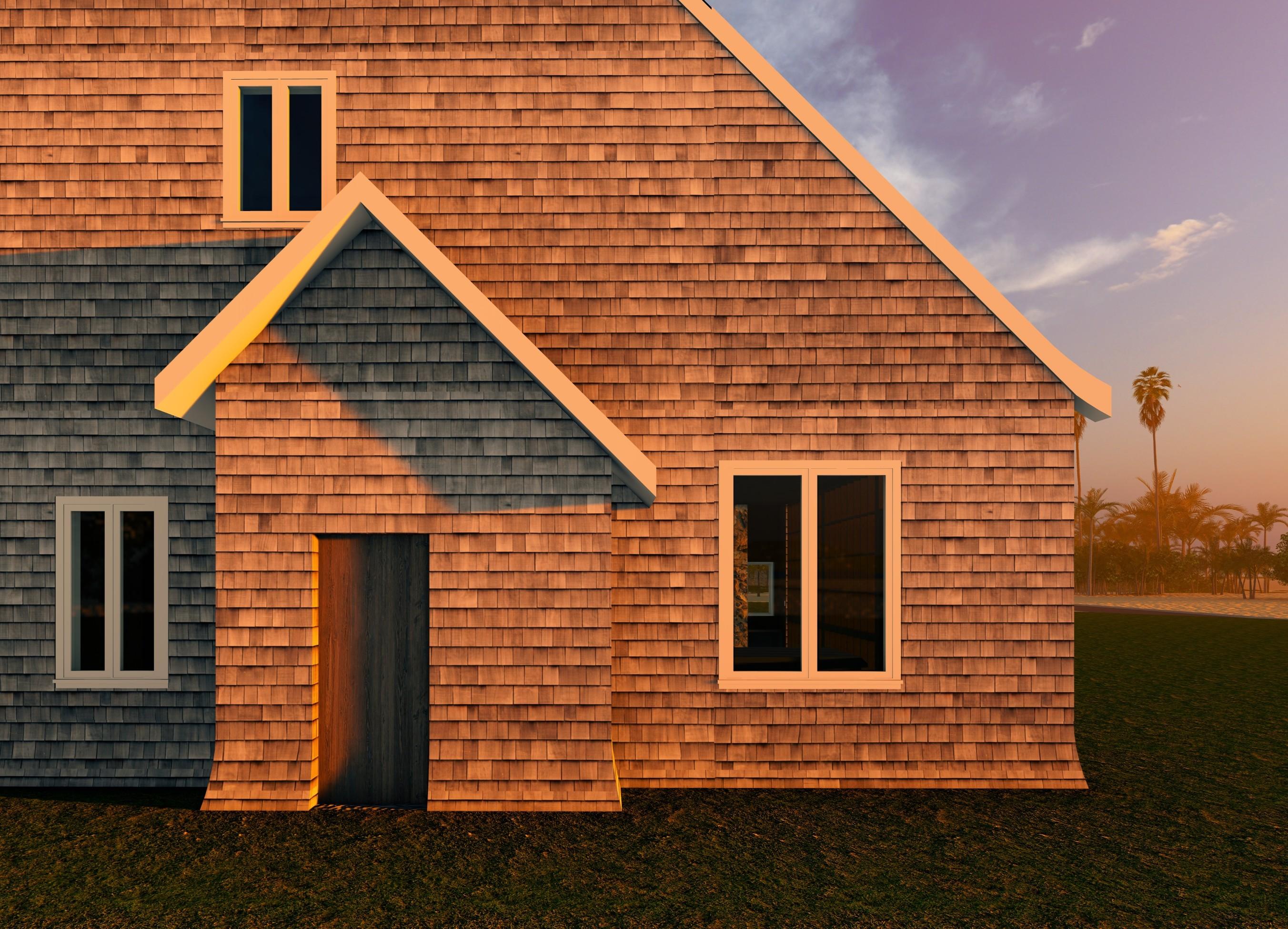 A close-up exterior view of a cedar-shingle house façade with simple windows and a small gabled entry, illuminated by warm sunset light.