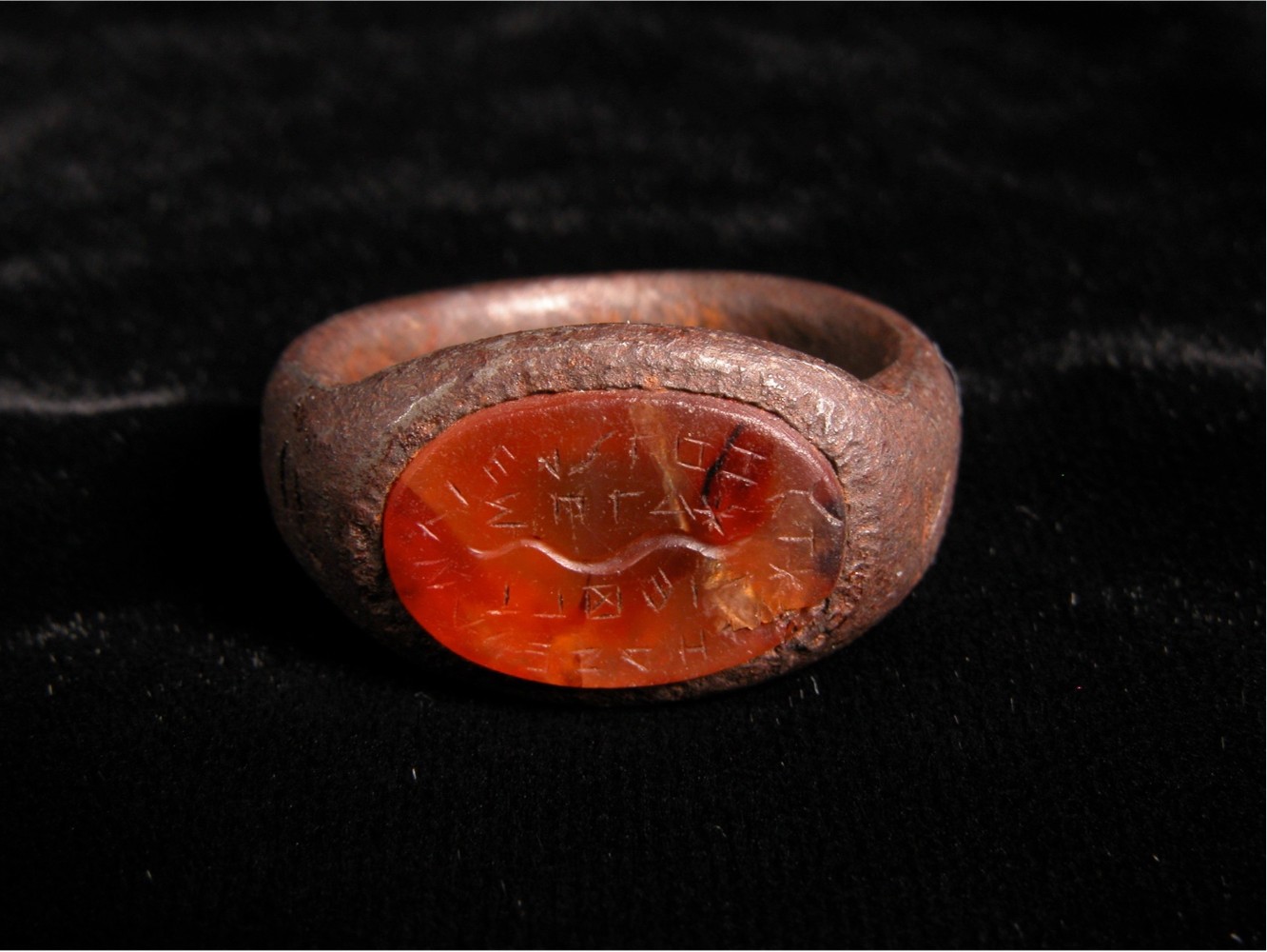 A battered ring with a seated red stone.
