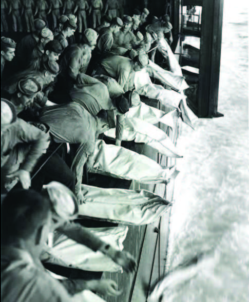 Deceased sailors in body bags being released into the sea.